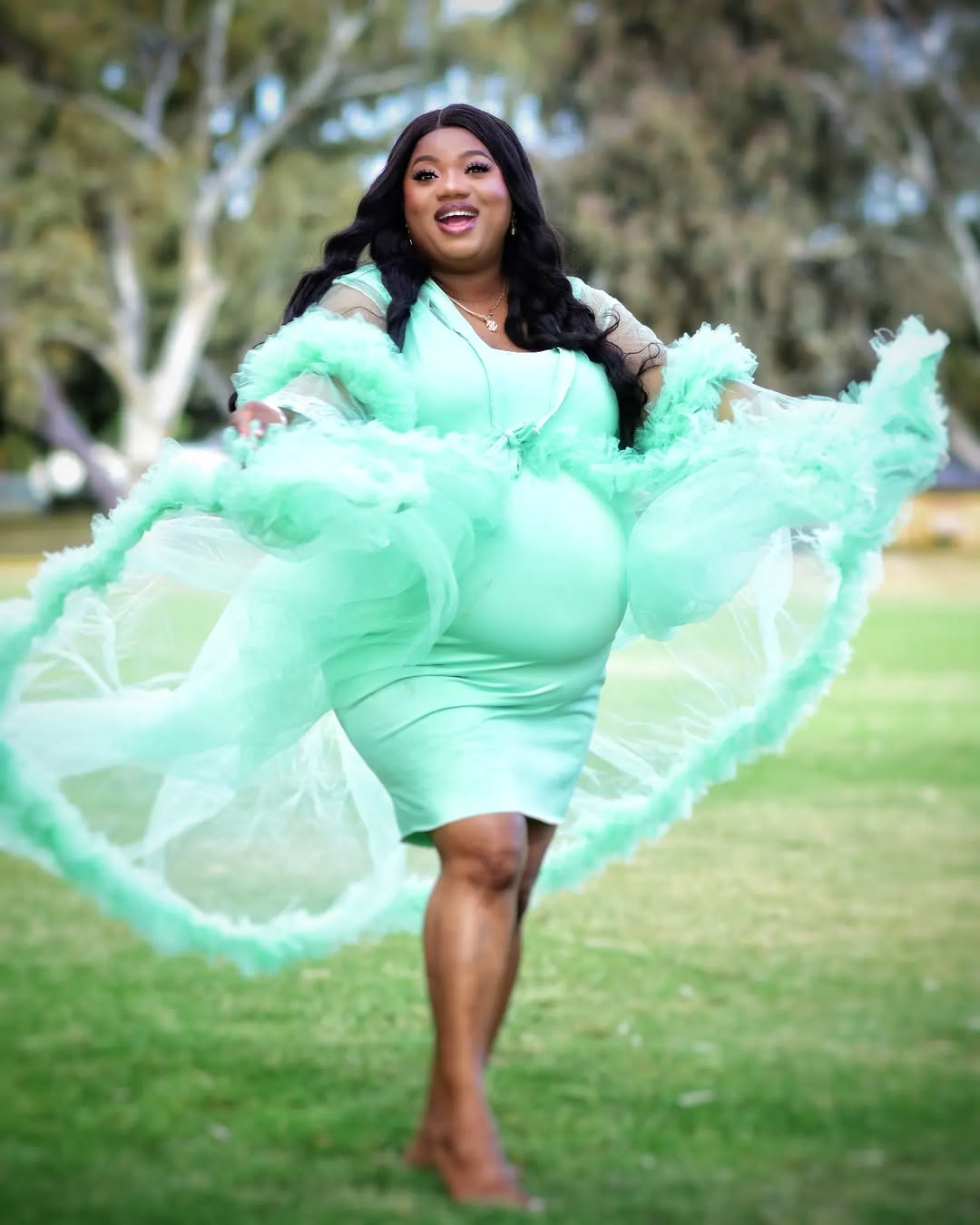 Joyful maternity portrait in flowing mint green tulle dress