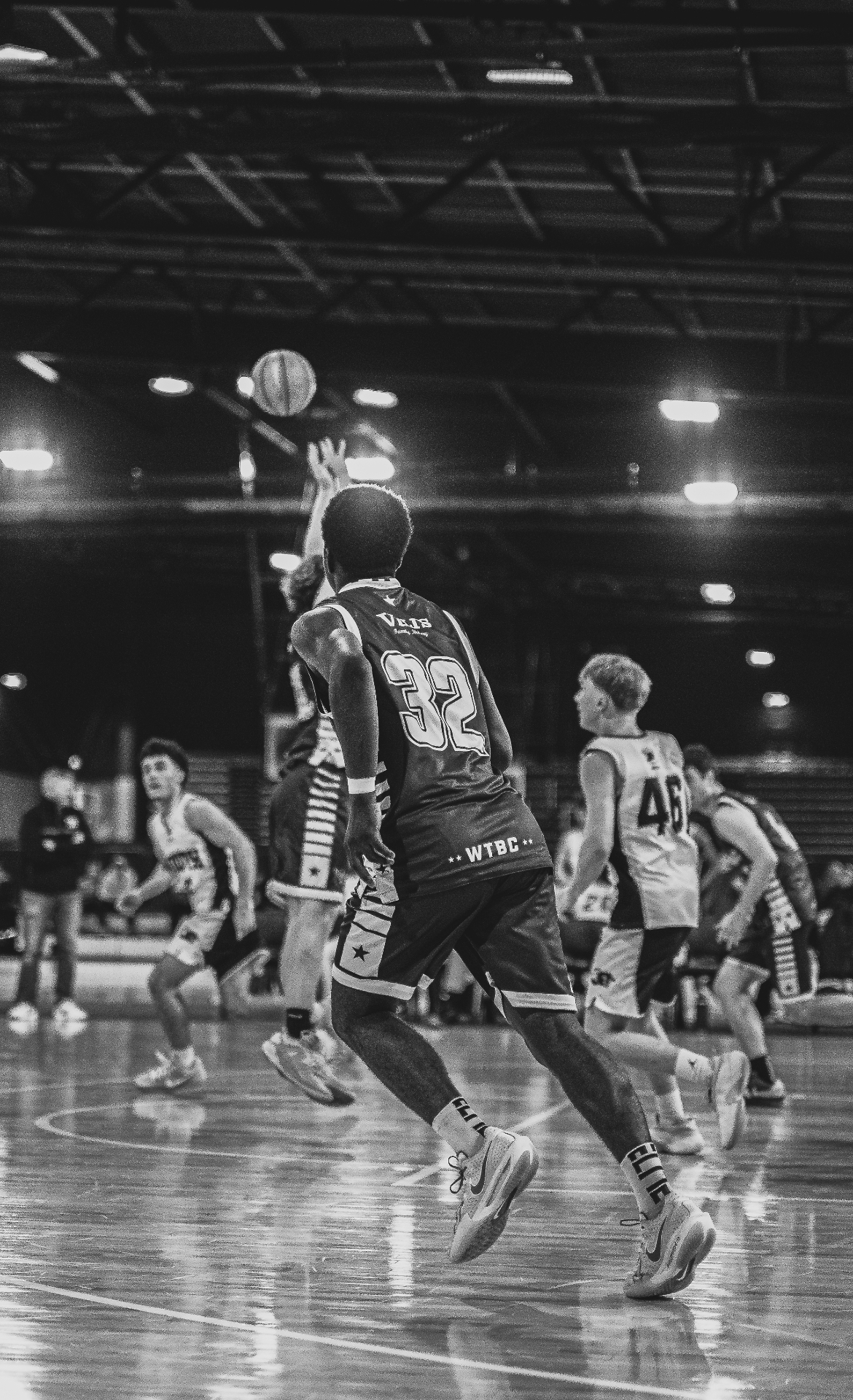 Basketball player taking a jump shot, black and white