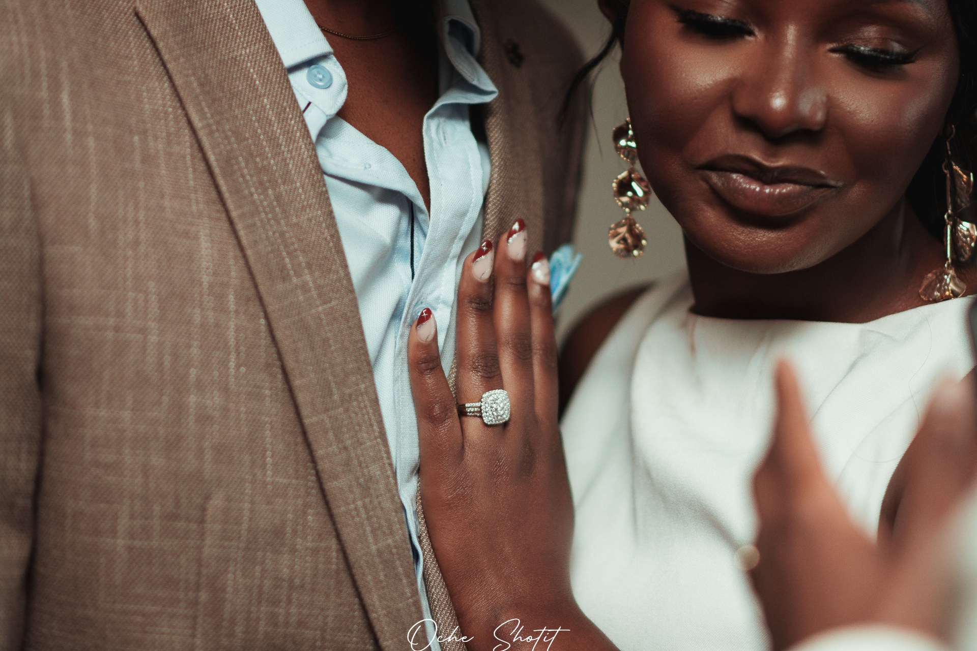 Close-up of engagement ring on couple in formal attire