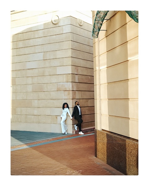 Couple standing at a city street corner in flat overcast light